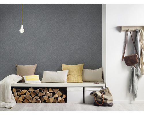 Entree met patroonbehang, bank met kussens en houtblokken, en kapstok met accessoires