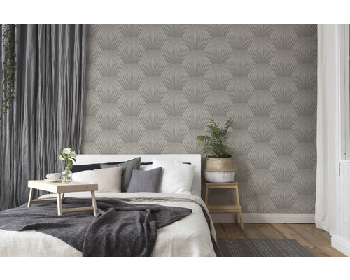 Slaapkamer met bed voor een muur met behang met geometrisch patroon