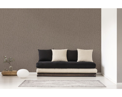 Een kamer met een bruin vliesbehang, een futon en decoraties.