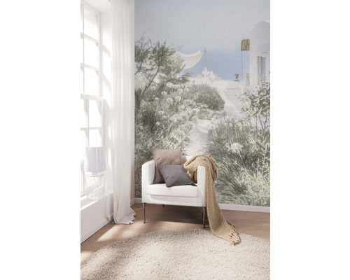 Woonkamer met fotobehang, fauteuil, kussens, sprei en vloerkleed voor een heldere en vriendelijke sfeer.