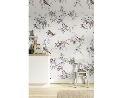 Kamer met behang met vogel- en bloemmotief, een witte kast en een stoel.