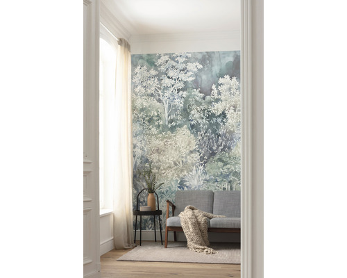 Woonkamer met een bosbehang, een bank, een bijzettafel en een vloerkleed.