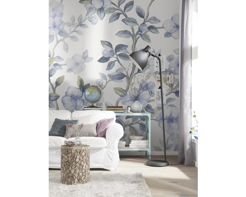 Gedecoreerde woonkamer met bank, bijzettafel en staande lamp voor een bloemenbehang