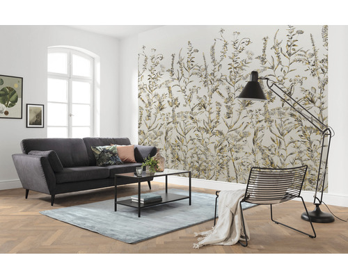 Woonkamer met bank, tapijt, vloerlamp, stoel en behang met plantmotieven