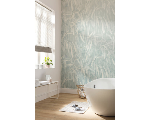 Badkamer met vrijstaand bad, behang met print en houten vloer