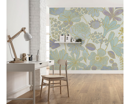 Een kamer met een bureau, een stoel en een bloemetjesbehang.