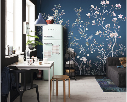 Woonkamer met koelkast, eettafel en behang met bloemmotief