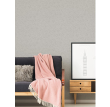 Woonkamer scène met behang, bank, kussen, deken, foto en dressoir