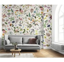 Woonkamer met bank en bloemenbehang met bladeren en bloemen.