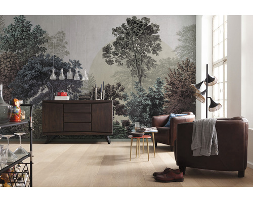 Woonkamer met een fotobehang met bosmotief, een dressoir en leren fauteuils.