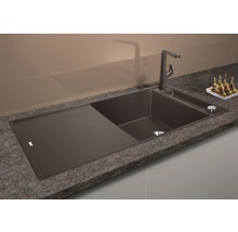 Spoelbak van composietmateriaal met afdruiprek en kraan op een aanrecht.