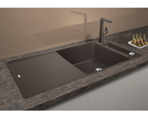 Spoelbak van composietmateriaal met afdruiprek en kraan op een aanrecht.