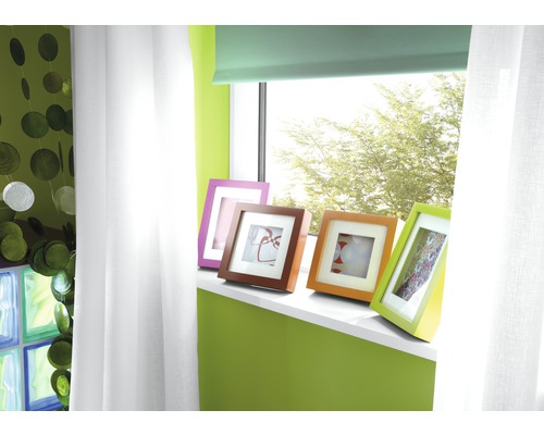 Decoratieve woonkamer met raam, gordijnen en kleurrijke fotolijsten