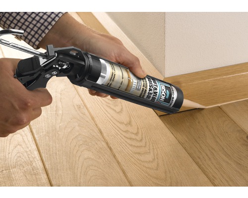 Toepassing van Bison hout en vloer lijm met een kitspuit op een houten vloer.