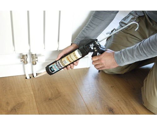 Persoon gebruikt een kitspuit om een verwarmingsbuis af te dichten