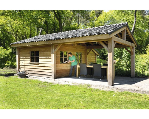 Houten tuinhuis met pannendak en tuinset in de tuin.