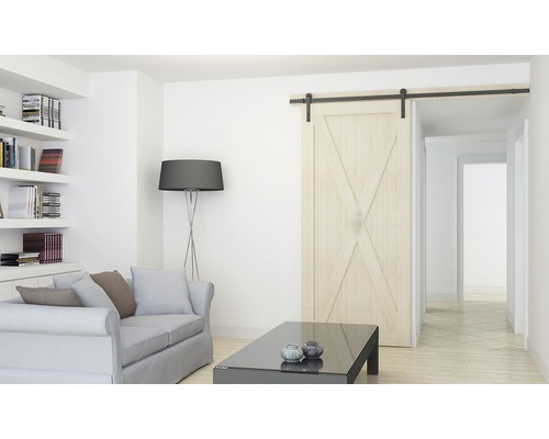 Lichte woonkamer met schuifdeur in schuurstijl, bank, boekenkast en staande lamp