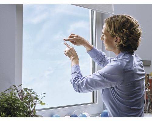 Vrouw brengt privacyfolie aan op het raam