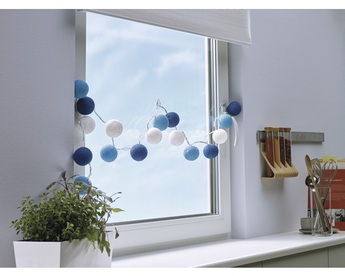 Gedecoreerd venster met lichtslinger, plant en keukengerei