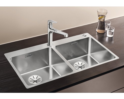 Roestvrijstalen spoelbak met twee bakken en kraan op een werkblad