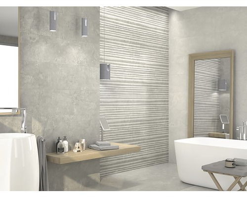 Badkamer met grijze tegels, ligbad, spiegel en opbergplank