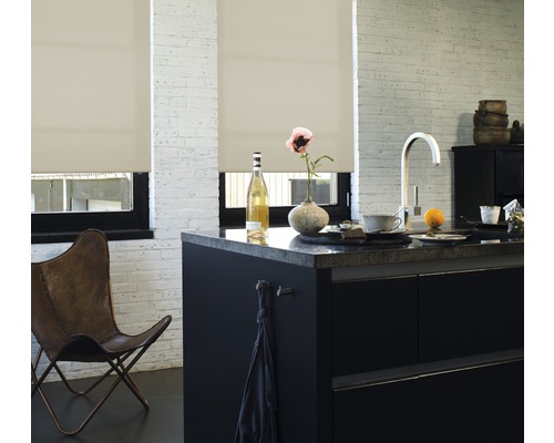 Lichte keuken met rolgordijnen voor de ramen, een kookeiland en een leren stoel.