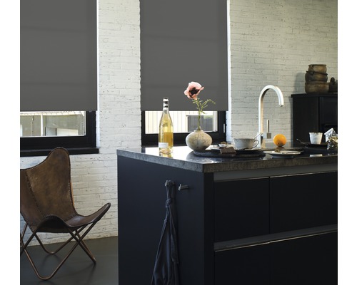 Donkere rolgordijnen aan ramen in een lichte keuken met kookeiland.