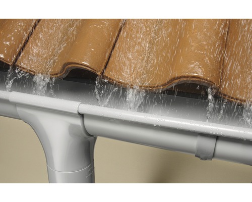 Regenwater stroomt van het dak in een kunststof dakgoot.