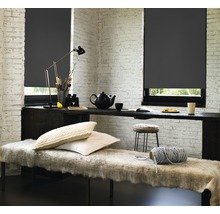 Lichte kamer met grijze rolgordijnen voor de ramen, tafel, bank en decoraties