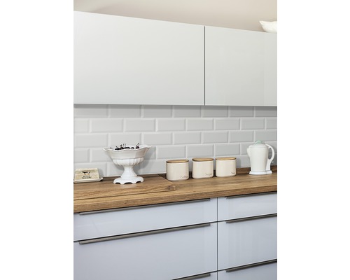 Keukenscène met witte kasten, houten aanrechtblad en witte tegels