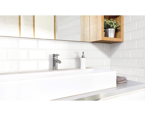 Moderne badkamer met wastafel, kraan, zeepdispenser en witte tegels