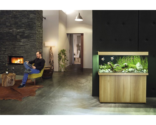 Woonkamer met aquarium, open haard en lezende man