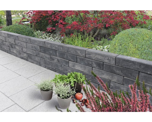 Tuinlandschap met muur van betonstenen en beplanting