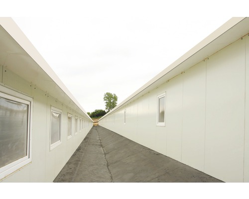 Lange gang tussen twee rijen kantoorcontainers met ramen