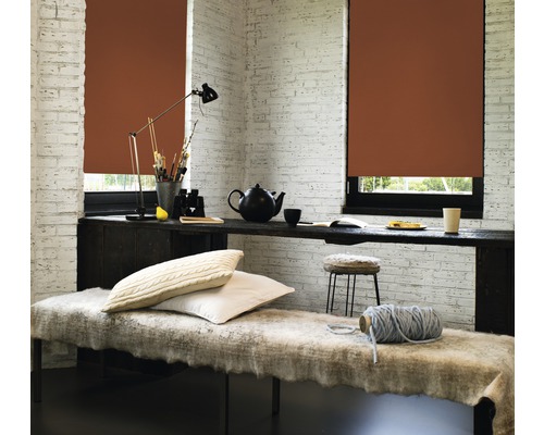 Gezellige kamer met bruine rolgordijnen voor de ramen, tafel met theepot en stoel.