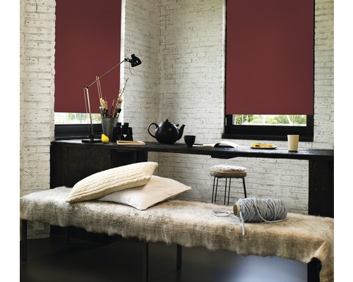 Lichte kamer met rolgordijnen, tafel, lamp, kussens en decoratieve objecten voor een gezellige sfeer