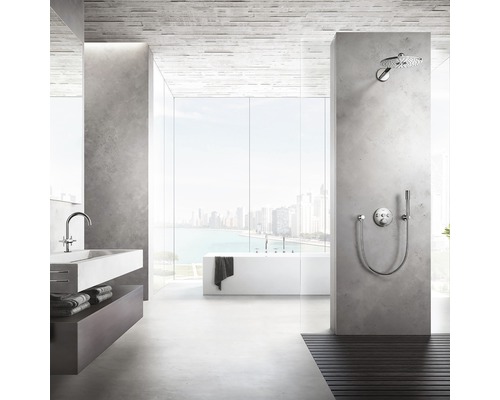 Lichte badkamer met wastafel, bad en douche voor een groot raam met uitzicht op de stad