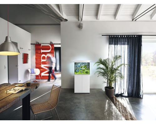 Woonkamer met aquarium op onderkast, tafel en stoelen.