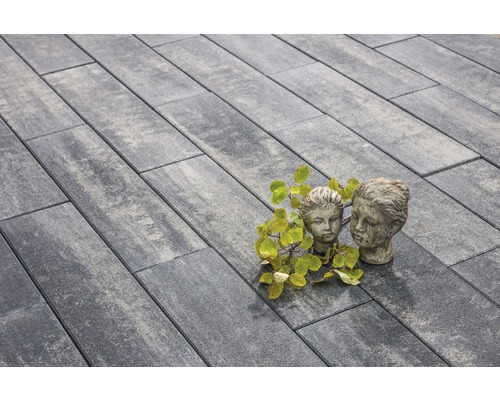 Bestrating van grijze straatstenen met twee beelden