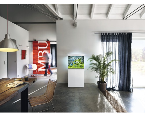 Woonkamer met aquarium op een onderkast, eettafel en gordijnen