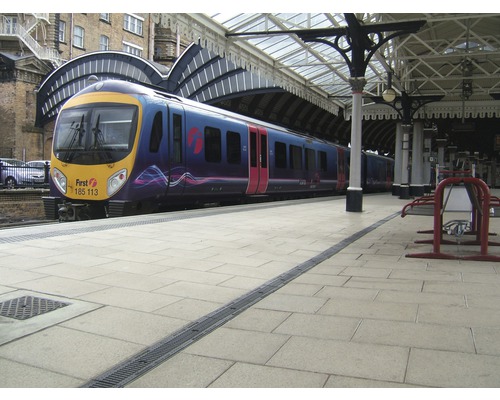 Een trein staat op het perron onder een perronoverkapping.