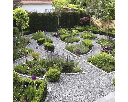 Tuinscene met grindpaden en beplante perken.