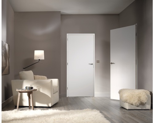 Lichte woonkamer met twee binnendeuren, fauteuil, lamp en vloerkleed