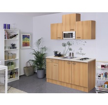Keuken met spoelbak, kookplaat, magnetron en opslag in een lichte ruimte.