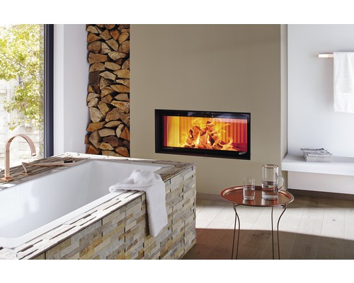 Badkamer met bad, open haard en stapel hout