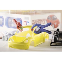 Gele Volkswagen New Beetle modelauto in aanbouw met gereedschap