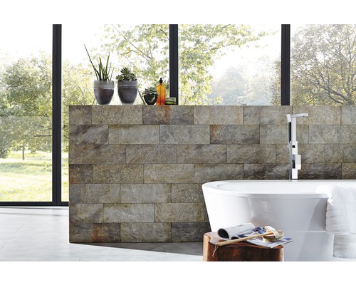 Moderne badkamer met natuurstenen muur, vrijstaand bad en kamerplanten