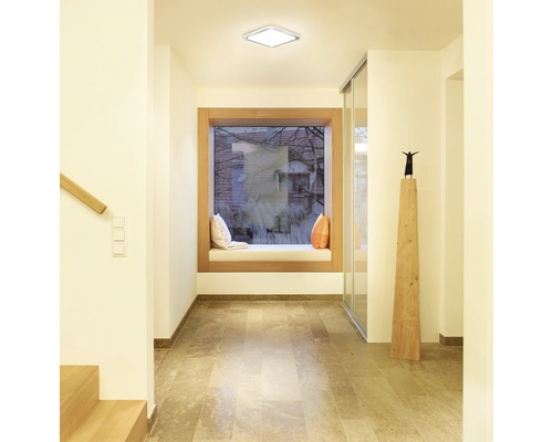 Hal met vierkante plafondlamp, vensterbank en stenen vloer