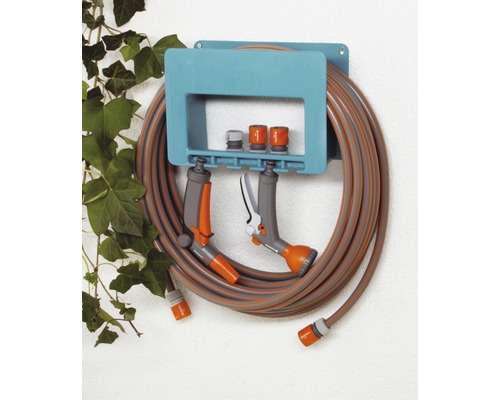 Gardena slanghouder met tuinslang, spuiten en koppelingen aan een muur