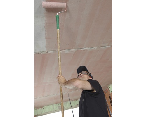 Man schildert plafond met verfroller op steel